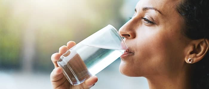 A woman drinking a fresh cup of water