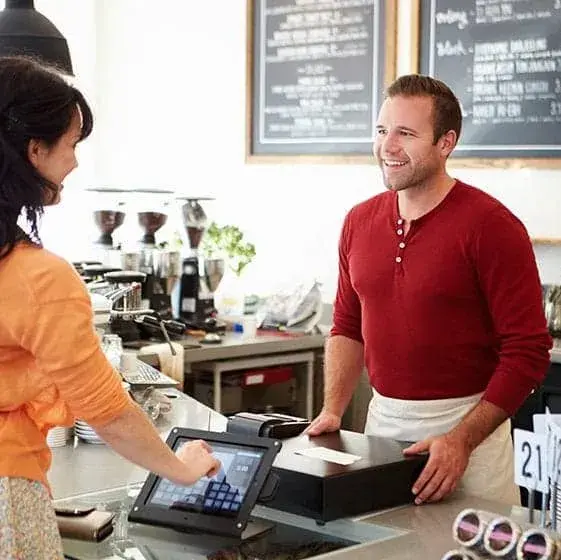 A man serving a woman at a bakery