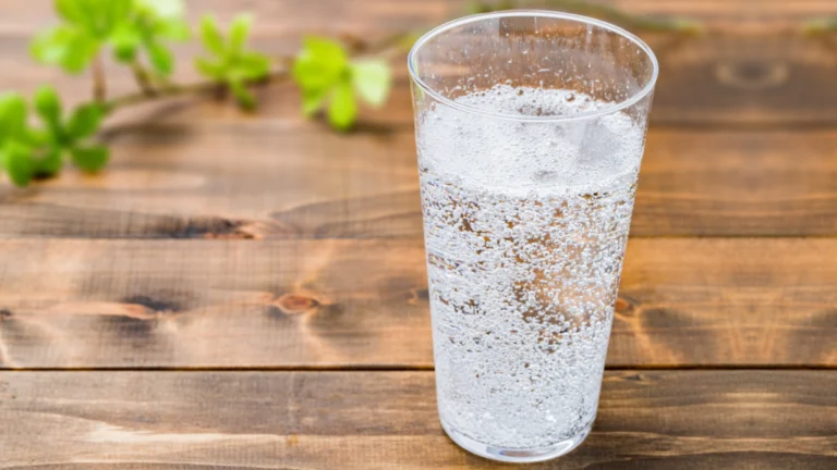 Glass of sparkling water on wooden table