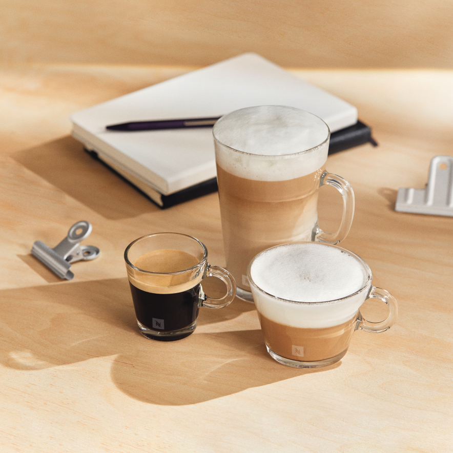 Three mugs of nespresso on a wooden table