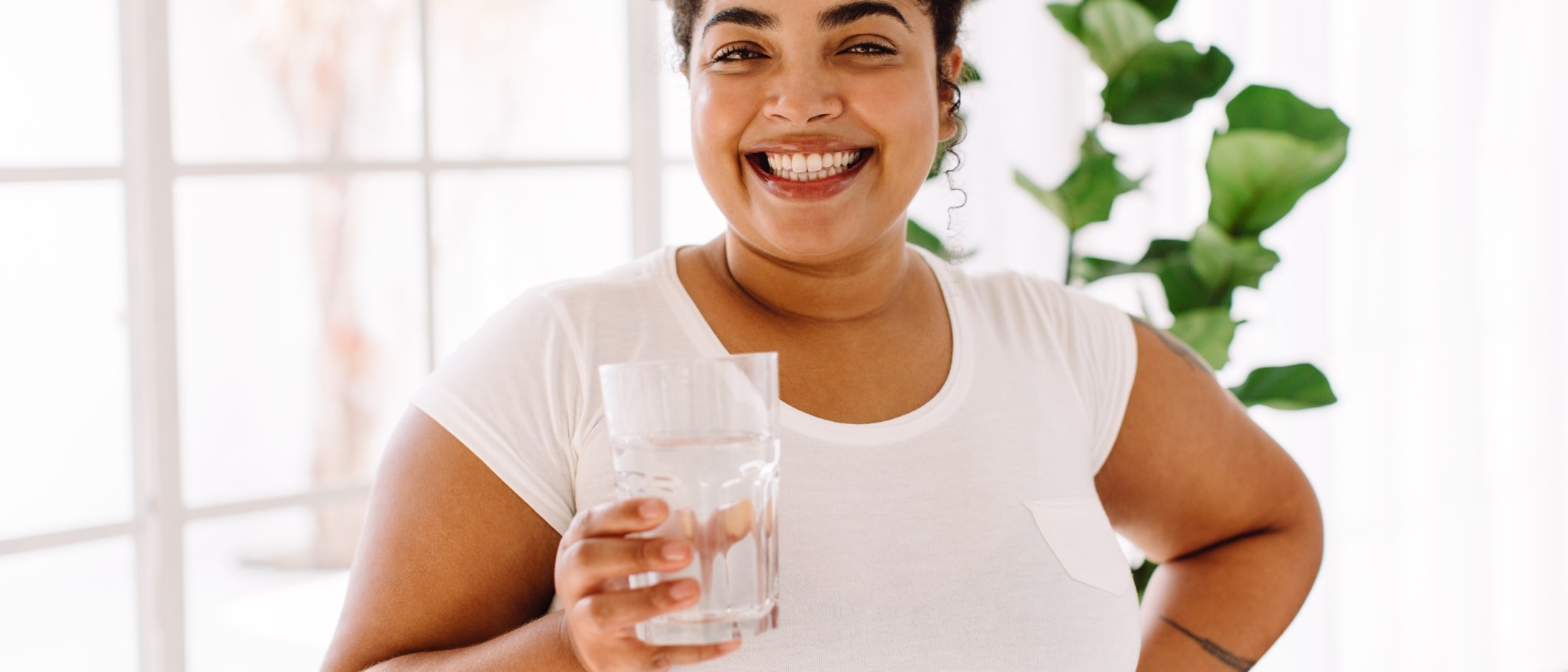 African American woman holding a glass of water