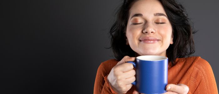 woman smelling coffee mug