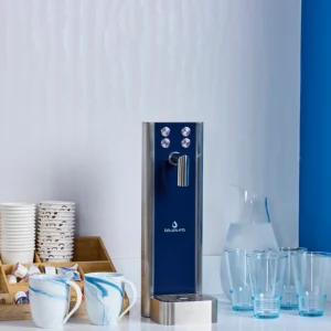Quench 580 sparkling water dispenser on counter with 2 mugs on the left and 4 glasses on the right
