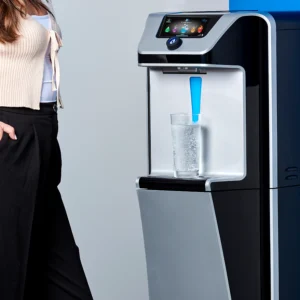 Woman waiting while water dispenses from Quench Q9 freestanding water dispenser