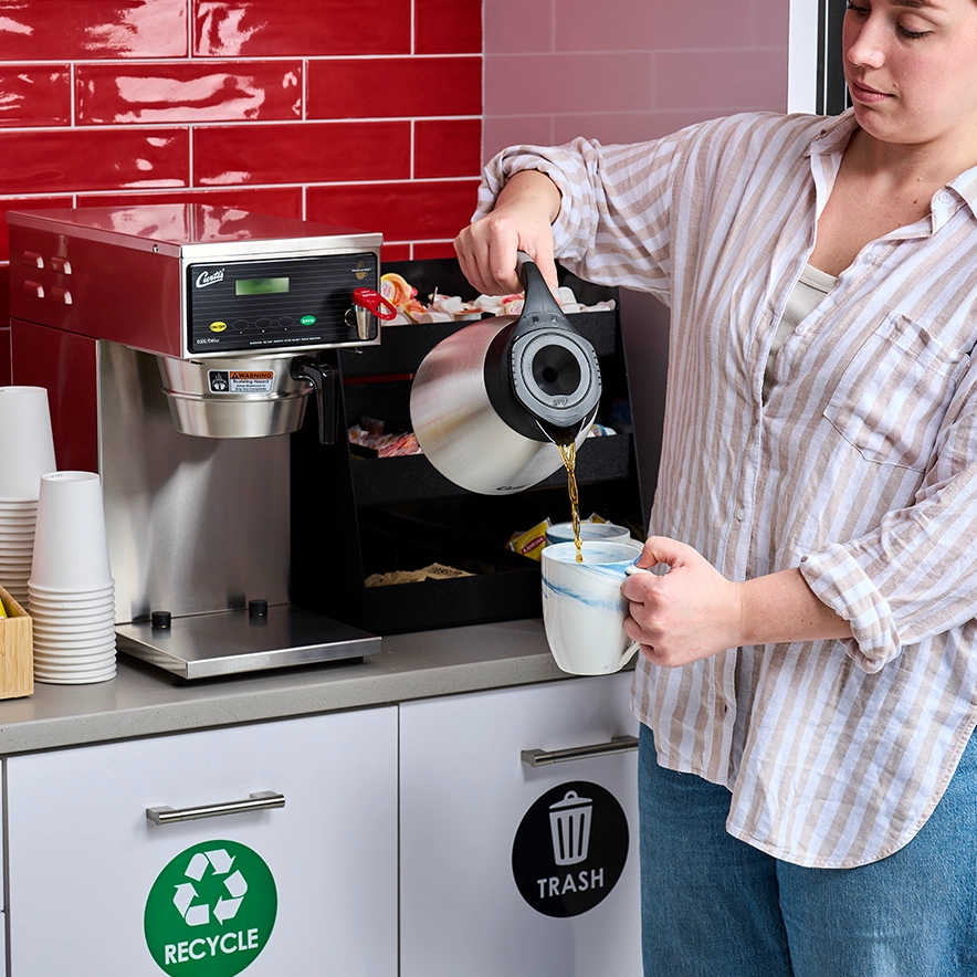 Woman pouring coffee from Quench 150 into a mug