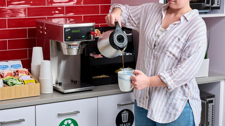 Woman pouring coffee from Quench 150 into a mug